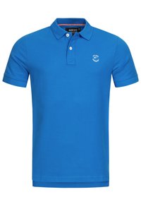 Sininen puuvillapaita, jossa on klassinen kaulus, lyhyet hihat ja pieni brodeerattu logo vasemmassa rinnassa.