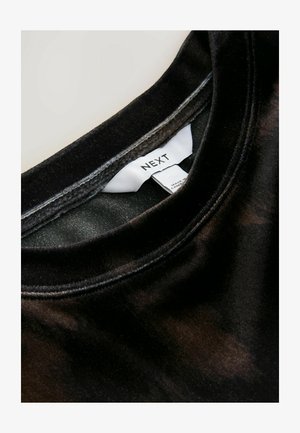 Tricou din bumbac negru cu guler rotund, având o textură netedă și un luciu subtil. Eticheta spune "NEXT" pe o etichetă albă în interiorul gulerului.