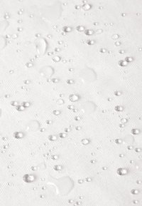 Gestructureerde witte stof met waterdruppels van verschillende groottes die over het oppervlak zijn verspreid, wat een waterdichte of waterafstotende eigenschap benadrukt.