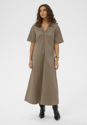 Dlhé béžové šaty s výstrihom do V a krátkymi rukávmi, vyrobené z hladkej látky s voľným strihom, siahajúce pod členky.