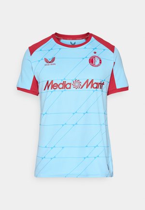 Camisa deportiva azul claro con acentos rojos en los hombros y las mangas, logo de Feyenoord Rotterdam, logo de Castore y texto de patrocinador de MediaMarkt en el frente.