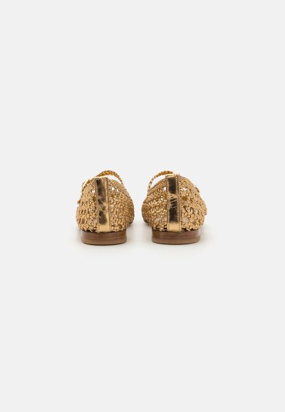 Zapatos de oro tejidos con un diseño abierto, que cuentan con un elegante acento de tacón metálico suave y una suela de madera marrón. Material texturizado y ligero.