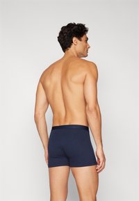 Marineblaue Baumwoll-Boxershorts mit einem glatten Bund, von hinten betrachtet, zeigen ein tailliertes Design und eine kurze Beinlänge.
