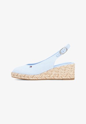 Lichtblauwe sleehak met slingback, gevlochten jute plateauzool en klein rood-wit-blauw logo aan de voorkant.