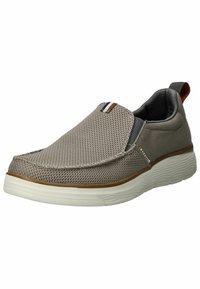 Zapatilla tipo slip-on fabricada en malla gris con una superficie texturizada, suela de goma blanca y un acento marrón en el talón. Presenta un diseño minimalista.