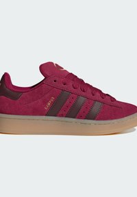 Baskets Adidas Campus en daim marron rouge avec des rayures brun foncé, semelle gomme et texte "CAMPUS" doré sur le côté.