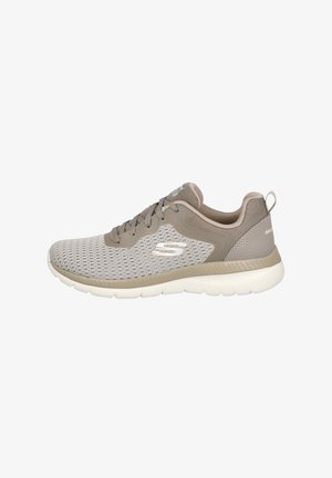 Zapatillas deportivas ligeras de malla gris con detalles en beige, diseño con cordones, parte superior texturizada y suela blanca flexible. Presentan un logo en el lateral.