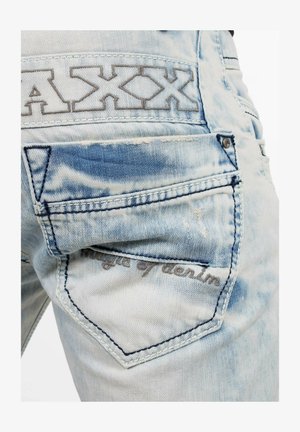 Lichtblauwe denim jeans met een versleten textuur, voorzien van een achterzak met geborduurde tekst "Magic of denim" en een logo patch.