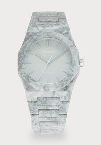 Reloj de policarbonato con una esfera octogonal, patrón de camuflaje en gris claro y blanco, manecillas luminiscentes y acentos de hardware plateados.