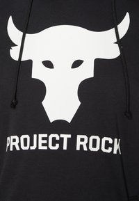 Musta collegepaita, jossa suuri valkoinen härkälogo ja alla suurilla valkoisilla kirjaimilla teksti "PROJECT ROCK". Pehmeä kangas, jossa nyörisäätö.