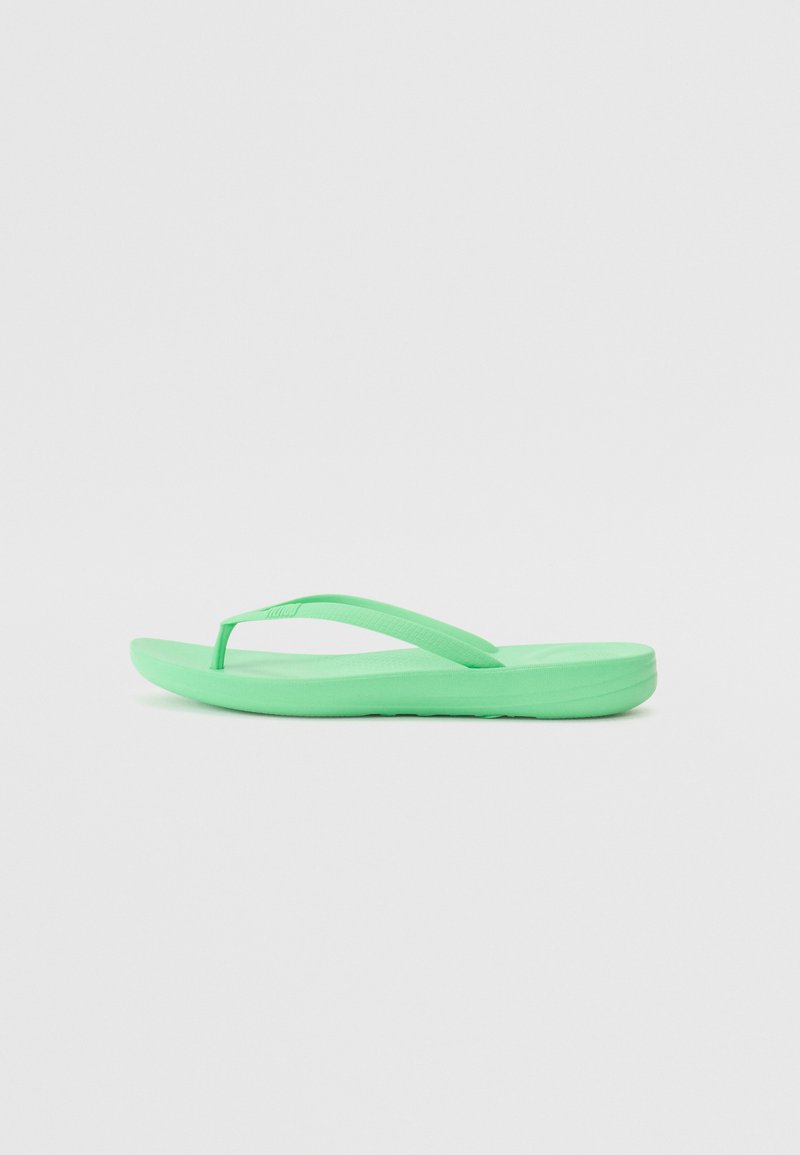 Roheline plätu, mis on valmistatud kummist, millel on lame talla ja õhukesed, tekstureeritud rihmad. Kujundus on minimalistlik, ilma lisamustrite või detailideta.