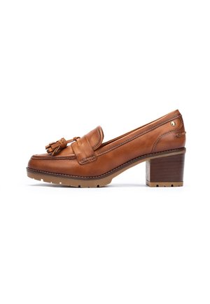 Mocasines de cuero marrón con acento de borlas, punta redondeada, tacón moderado y suela de goma texturizada. Presenta costuras tono sobre tono y detalle de logo.