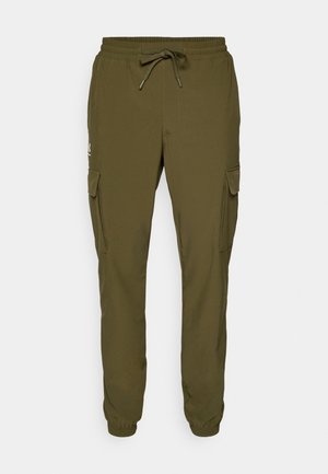 Pantalons cargo verts avec une taille élastique et un cordon de serrage. Comprend deux poches latérales et des poignets fuselés. Fabriqués en matériau léger.