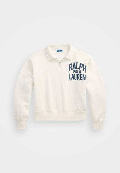 Hvit fjerde-dels glidelås genser med ribbestrikkede mansjetter og kant. Har marineblå tekst: "RALPH POLO LAUREN" på venstre brystområde. Myk stoffkvalitet.