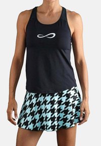 Zwart atletisch tanktop met wit infinity-logo, gecombineerd met een lichtblauwe rok met een zwart hondenbotpatroon.