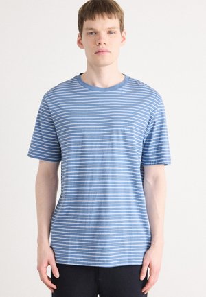 Blauwe katoenen t-shirt met horizontale witte strepen, korte mouwen en een ronde hals. Kleine logodetail op de borst. Zachte textuur.