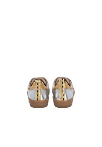 Vista posteriore di sneakers con accenti metallici argento e oro, dettagli in pelle marrone e suole in gomma. Presentano cuciture decorative.