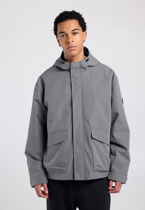 Light gray hooded jacket with a zip front, two large flap pockets, and a relaxed fit. Made from a smooth, water-resistant material.