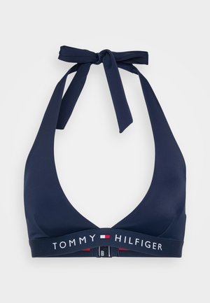 Marinblå halterneck-bikiniöverdel med en djup V-halsringning, som har ett märkt elastiskt band och en knuten nackrem. Slät yta och minimalistisk design.