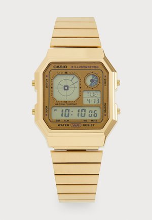 Auksinės spalvos skaitmeninis laikrodis su aštuonkampiu ciferblatu, guminiu dirželiu, LCD ekranu, rodančiu laiką ir datą, ir šoninėmis mygtukais nustatymams.