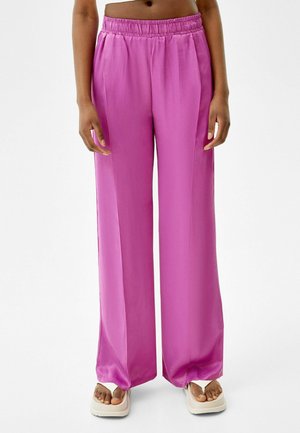 Pink satin wide-leg trousers with an elastic waistband, featuring a smooth texture and a loose fit, designed for comfort and ease of movement.