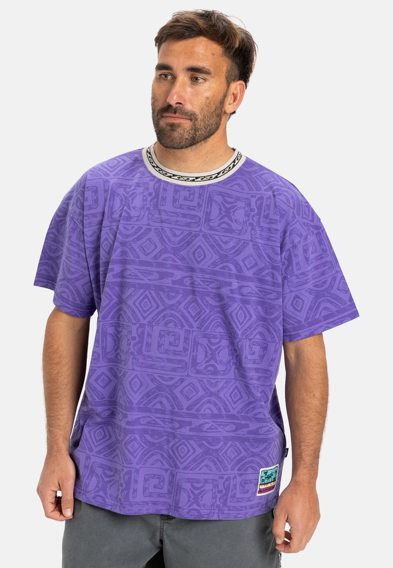 Fialová krátka rukávová tričko s textúrovaným tribal vzorom, kontrastný čierny a biely golier a nášivka s logom na leme. Voľný strih.