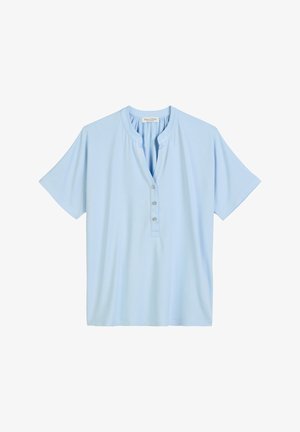Chemise bleu clair à manches courtes en tissu doux, avec un col henley et quatre boutons sur le devant, offrant une coupe décontractée.