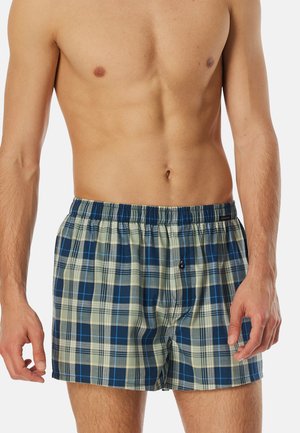 Karierten Boxershorts in Blau und Creme, aus leichtem Stoff. Mit einem elastischen Bund und einem Knopfverschluss vorne.