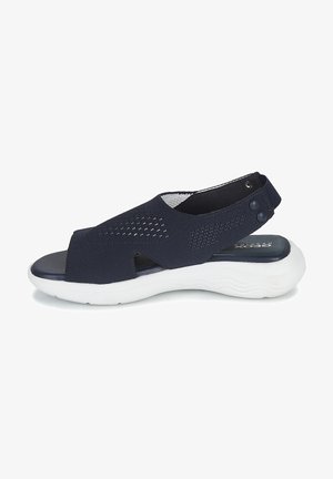 Sandalias de tela azul marino con diseño de recortes, suela blanca texturizada, correa ajustable con broches y plantilla acolchada.