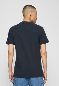 Marineblå bomulds T-shirt med korte ærmer og rund halsudskæring, med et ensfarvet design og en afslappet pasform.