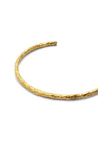 Brazalete de puño en tono dorado con un diseño texturizado y torcido. Presenta una forma abierta y suave, destacando su acabado metálico y su patrón único.