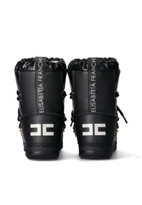 Stivali neri con finitura lucida, caratterizzati da un collo arricciato, accessori in oro, etichetta verticale con marchio e un audace logo bianco sul tallone.