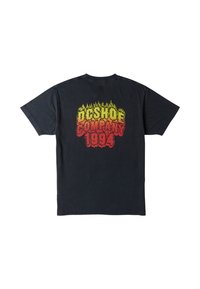 T-shirt en coton noir avec un grand graphisme multicolore au dos, comprenant un texte en forme de flammes de couleur rouge, jaune et orange. Coupe standard.