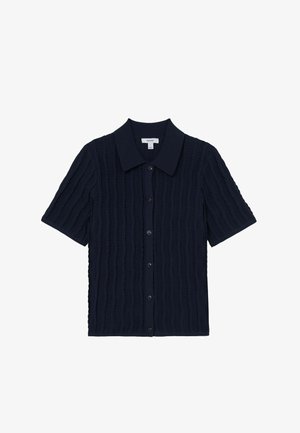 Krátky pletený kardigán námorníckej modrej farby s textúrovanými vertikálnymi pruhmi, zapínaním na gombíky vpredu a širokým špicatým golierom.