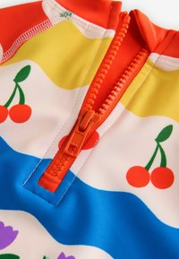 Kleurige zwemkleding met een rits aan de voorkant, versierd met een patroon van kersen, tulpen en golvende strepen in rood, geel, blauw en wit. Zachte textuur.