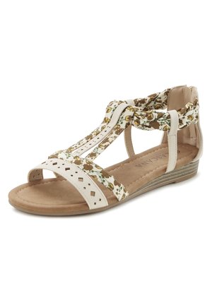 Offene Sandalen mit einem weißen perforierten Leder-Obermaterial, floralen Stoffakzenten und einem niedrigen braunen Keilabsatz mit strukturiertem Profil.