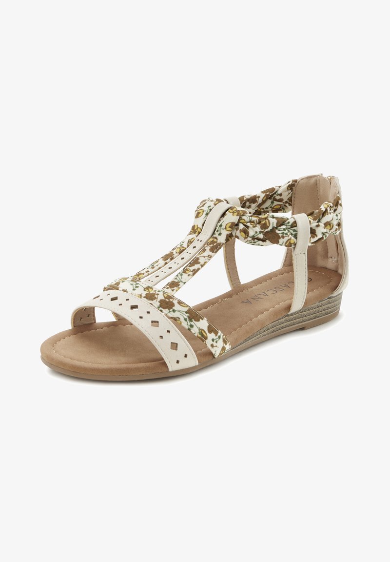 Offene Sandalen mit einem weißen perforierten Leder-Obermaterial, floralen Stoffakzenten und einem niedrigen braunen Keilabsatz mit strukturiertem Profil.