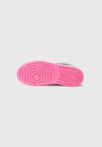 Nike'i jalanõu tald, millel on roosa kummist välistald ringjate ja sirgete mustritega. Vahevaht on valge siniste aktsentidega.