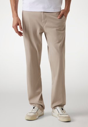 Pantalones beige con diseño de pierna recta hechos de una tela suave. Presentan dos bolsillos frontales, cinturilla elástica y una ligera textura en la superficie.