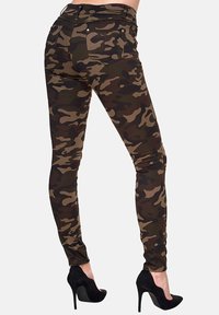 Tarnfarben Skinny-Jeans in einer Mischung aus Grün, Braun und Schwarz mit hoher Taille und Fünf-Taschen-Design, aus Denim-Material gefertigt.