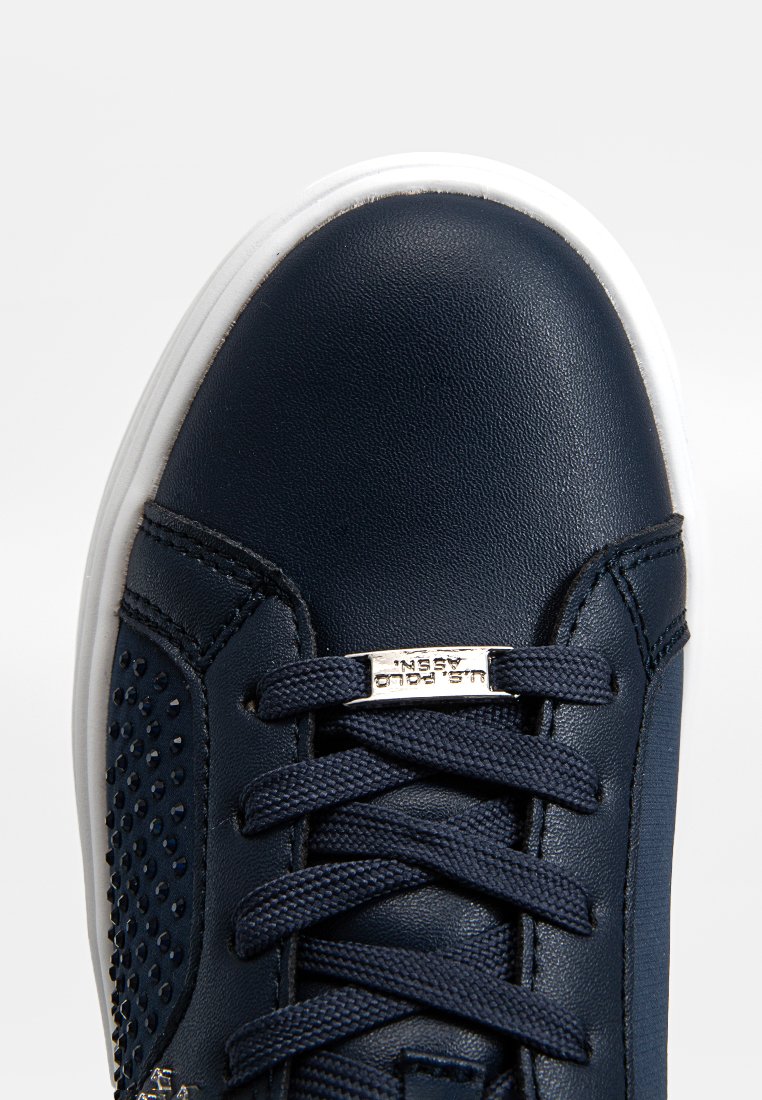 Sneaker di pelle blu navy con suola in gomma bianca, design con lacci, dettagli perforati e piastrella con logo in argento sul lato.