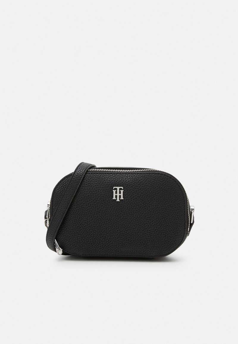 Borsa a tracolla nera con texture, zip argentata e logo "TH" sul davanti, dotata di una tracolla regolabile su uno sfondo bianco.