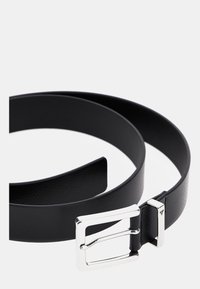 Cintura in pelle nera con una superficie liscia, dotata di una fibbia in metallo argentato e un design minimale.