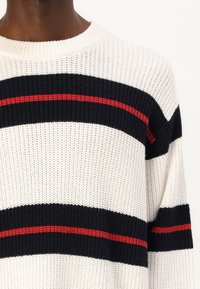 Suéter de punto con rayas en blanco, azul marino y rojo; escote redondo; tejido texturizado; corte holgado; mangas cortas.