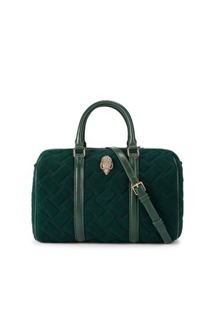 Velvet green handbag with quilted design, dual top handles, and an adjustable strap. Features a decorative shell-shaped clasp detail.