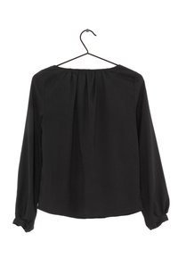 Svart blus med långa ärmar och rund halsringning, med rynkad detalj på baksidan och knapppynt på ärmaren. Slät tygtextur.