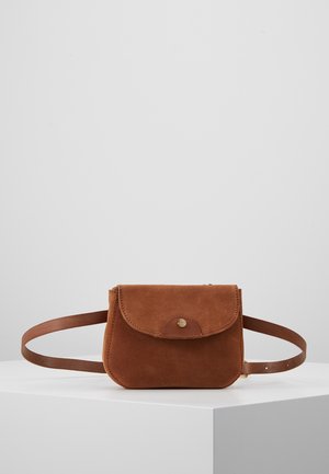 Sac banane en daim marron avec rabat et fermeture à bouton, exposé sur un socle blanc sur fond gris.
