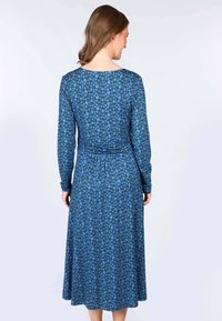 Langärmliges Kleid in Dunkelblau mit floralem Muster, das einen taillierten Oberteil und eine geraffte Taille hat und bis zur Mitte der Waden fließt.