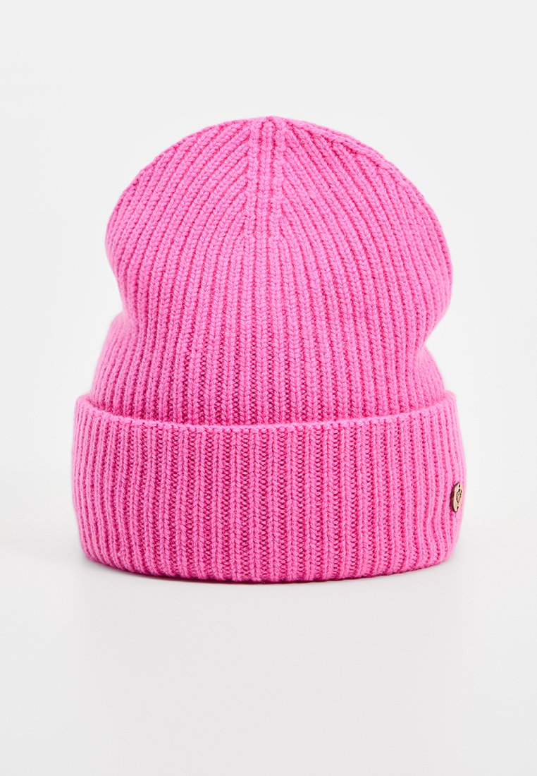 Różowa, prążkowana czapka dzianinowa z zawiniętym mankietem i małym okrągłym logo, z miękką teksturą i bezszwowym designem na szczycie.