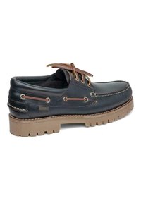 Zapato náutico de cuero negro con cordones marrones, que presenta una suela de goma con tacos, costuras en contraste y ojales laterales. Diseño duradero y clásico.